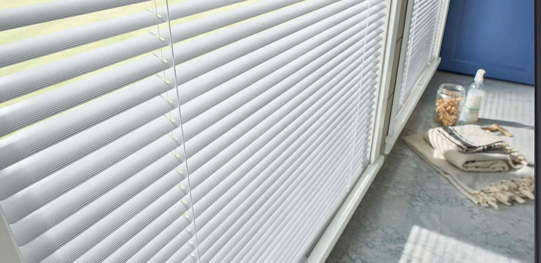 Horizontal blinds tilted open across an interior window