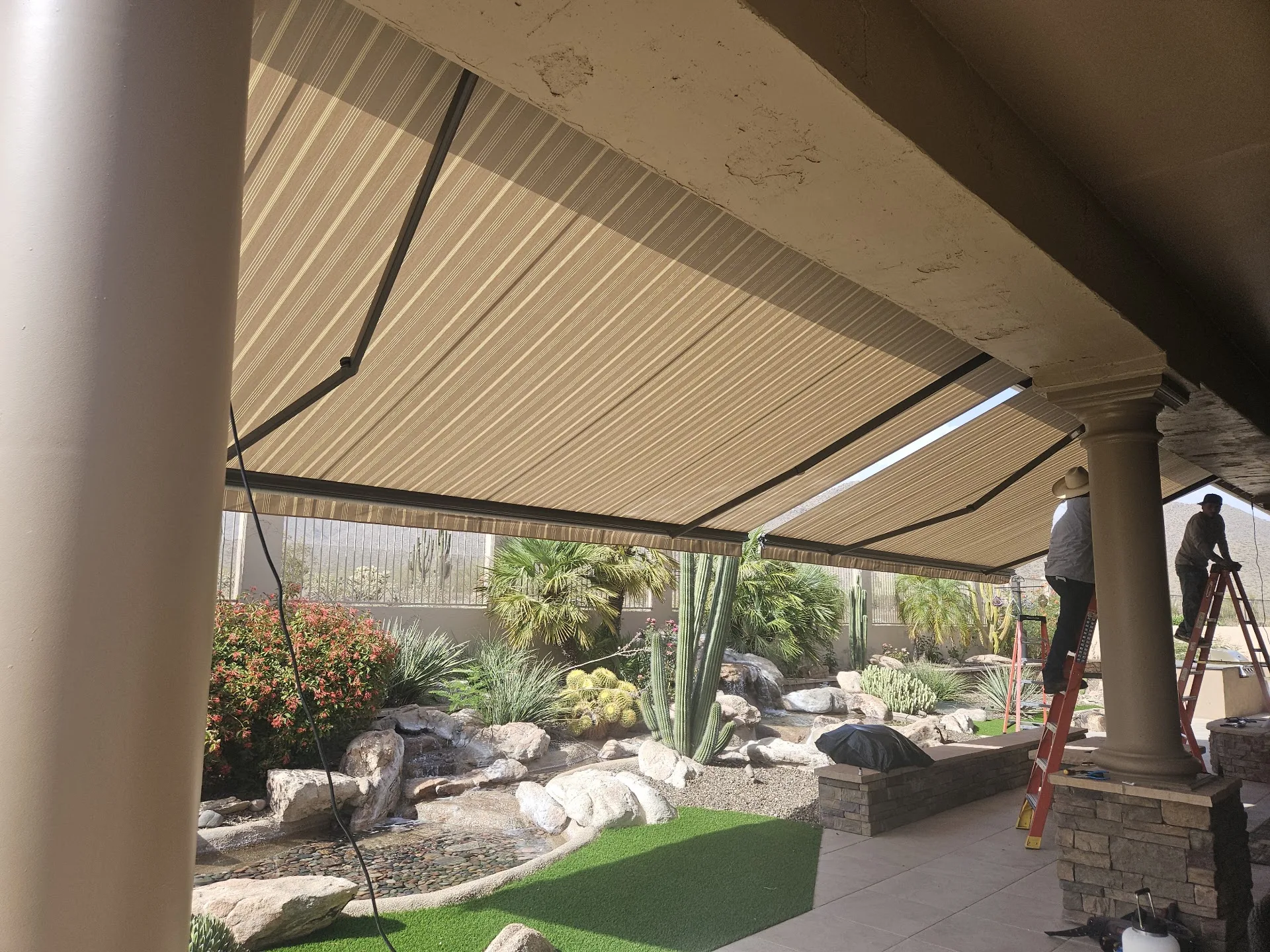 Retractable awning lowered over a paver patio at an Arizona home